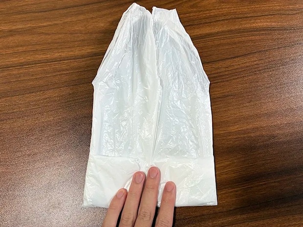ビニール袋の左右から半分にたたむ場面（撮影：grapeライフハック編集部）