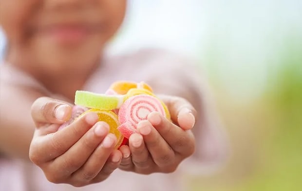 お菓子を差し出す女の子の写真