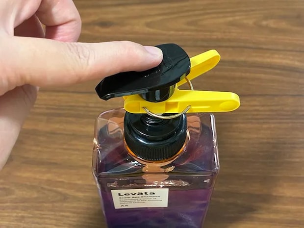 洗濯バサミのついたシャンプーのボトルを押す場面（撮影：grapeライフハック編集部）