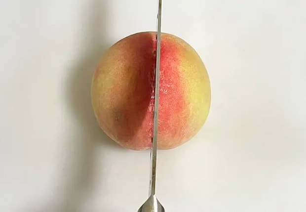 桃を縦に切る写真（撮影：grapeフード編集部）
