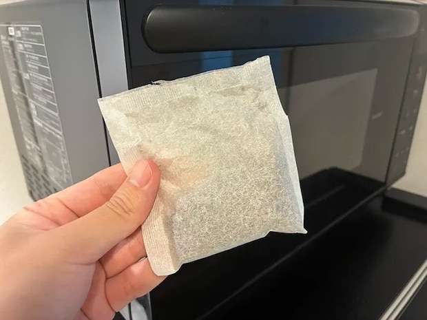 電子レンジの前で手にする麦茶パック（撮影：grapeフード編集部）