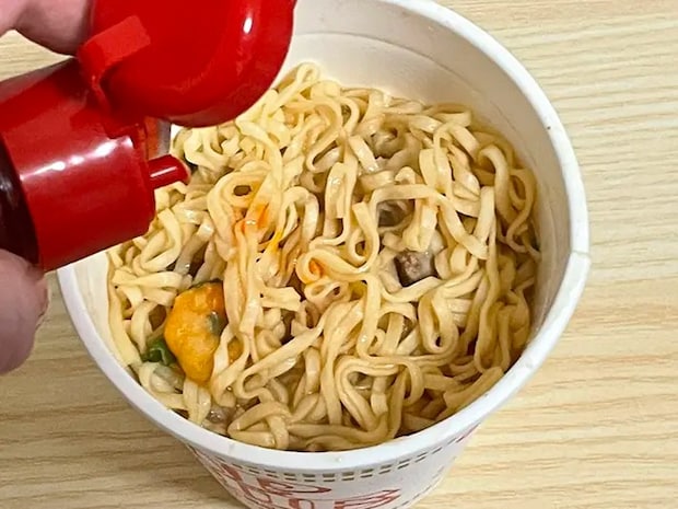 『カップヌードル』にラー油を入れる写真（撮影：grapeフード編集部）