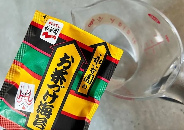 お茶漬けの素を水を入れた計量カップに加える画像（撮影:エニママ）