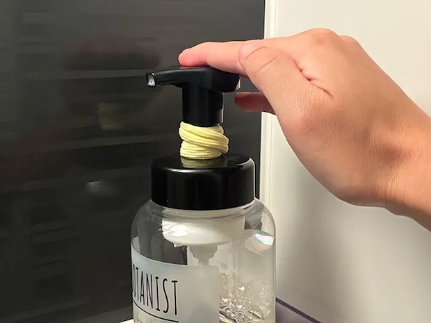 ヘアゴムをつけたボディソープのボトルを押す場面（撮影：grapeライフハック編集部）