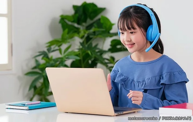 青いヘッドホンをする子供の写真