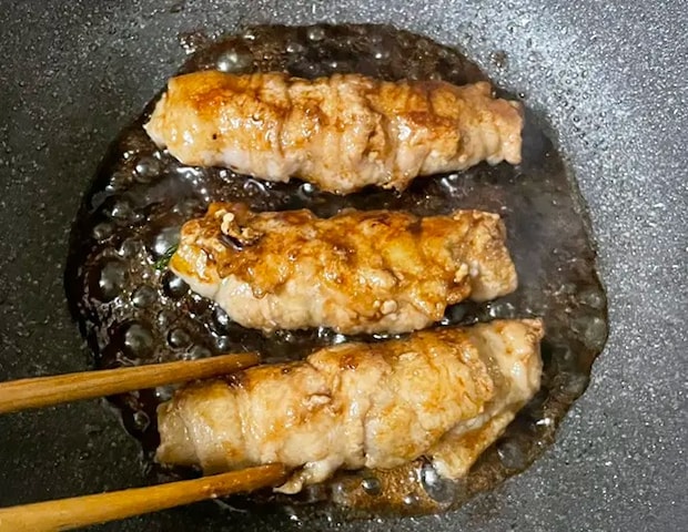 チンゲン菜の肉巻きを調味料に絡める写真（撮影：grapeフード編集部）