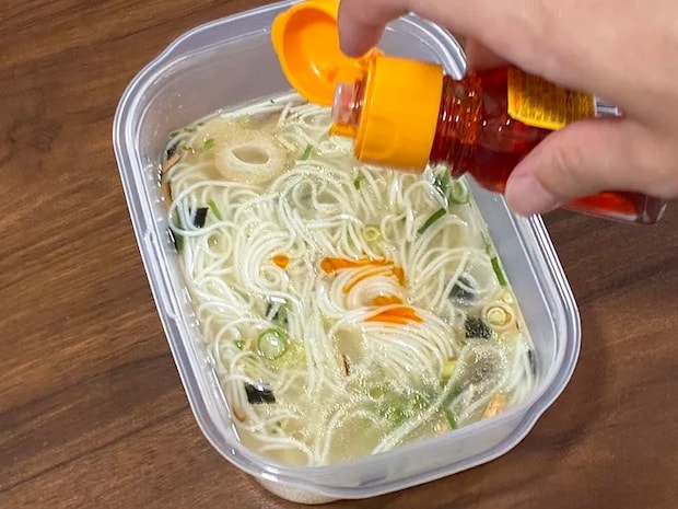 そうめんにラー油を加える場面（撮影：grapeフード編集部）