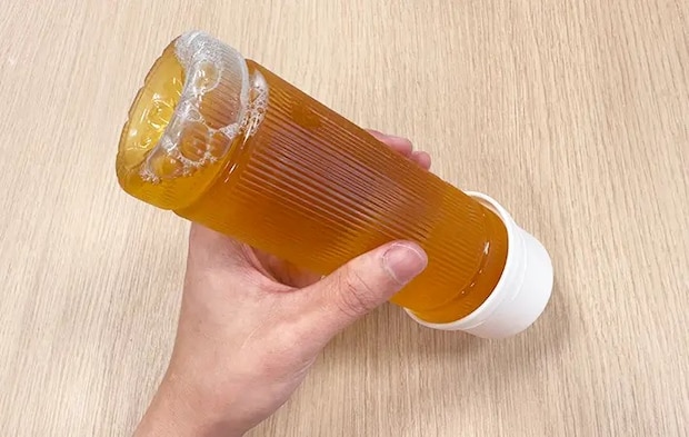 スリコのハンドル付きペットボトル用コップをペットボトル飲料につけている写真（撮影：grape編集部）