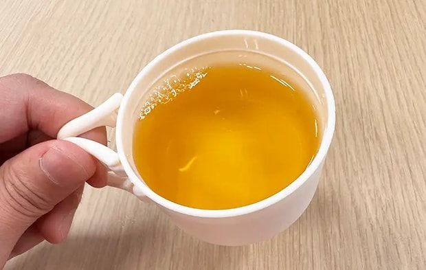 スリコのハンドル付きペットボトル用コップをペットボトル飲料につけている写真（撮影：grape編集部）