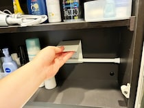 『洗面棚の内壁』につっぱり棒をセット　ブックエンドと組み合わせる収納ワザとは