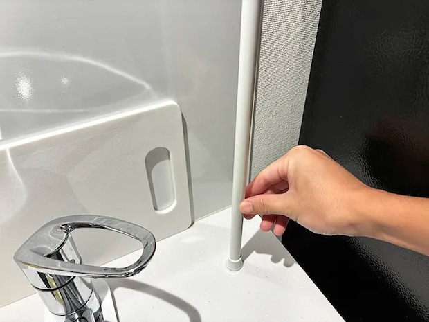 つっぱり棒をシンク台にセットする場面（撮影：grapeライフハック編集部）