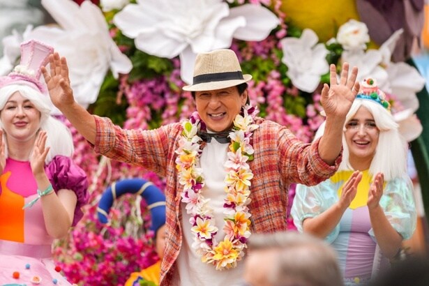 歓迎する街の人々に対して笑顔で応えていくジャッキー