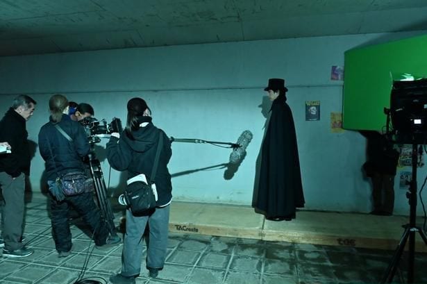 【写真を見る】青木涼演じる怪しげな黒マントの男！グリーンバックで撮影中