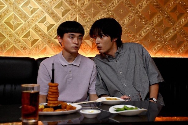 カラオケ店で驚いた表情を浮かべる(写真右)都成(水上恒司)