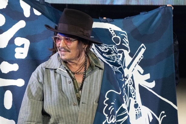 尾田栄一郎氏から贈られたジャック・スパロウの暖簾を気に入った様子のジョニー・デップ