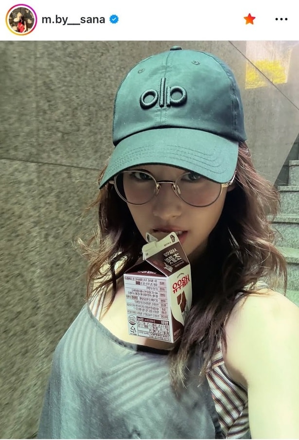 【写真】TWICE・サナ、タンクトップ1枚とキャップ姿でチョコ牛乳を咥えている“オフ感”満載の姿