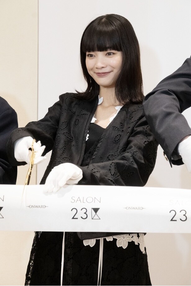 少し緊張した表情でテープにハサミを入れる見上愛