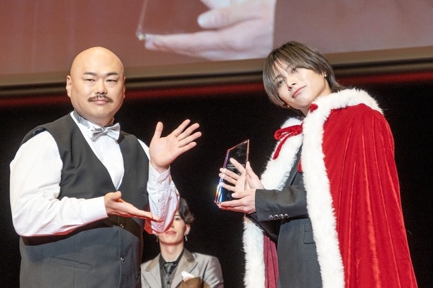 クロちゃんから記念品のクリスタルトロフィーを受け取る原田樹