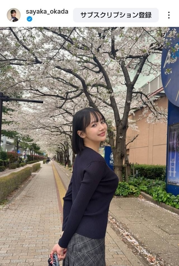 【写真】見事な桜並木を背景に笑顔の岡田紗佳
