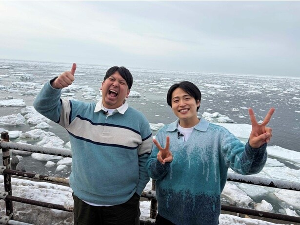 流氷をバックにポーズするレインボー・ジャンボたかおと池田直人