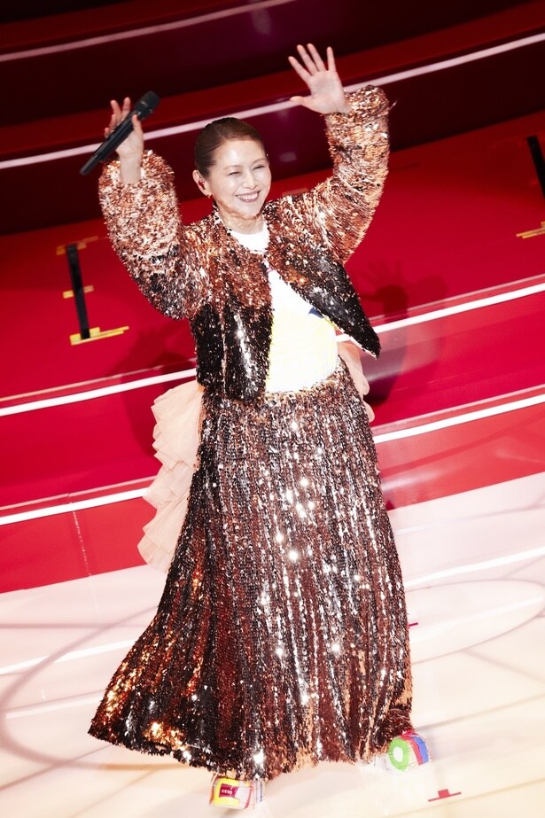 キラキラと輝くゴージャスな衣装でファンに手を振る小泉今日子