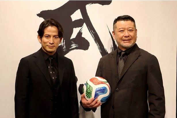 サッカーボールを手に笑顔を見せる岡田准一とケンドーコバヤシ