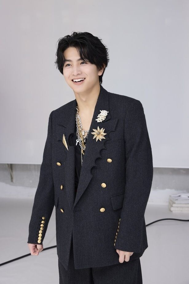 スタジオに入ってきて、壁一面の自身の写真にこの笑顔