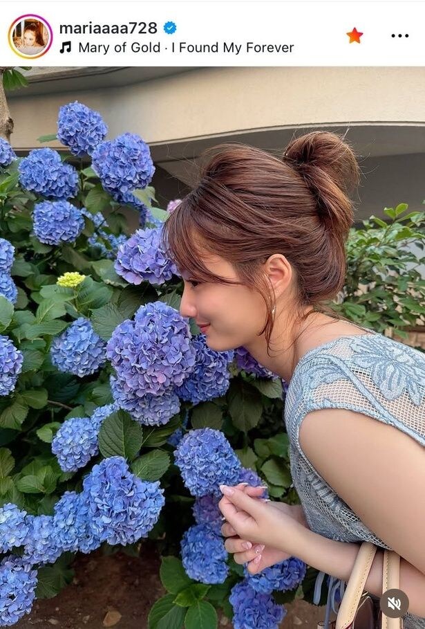 【写真】谷まりあ、あじさい色のワンピで花壇に顔を寄せた姿