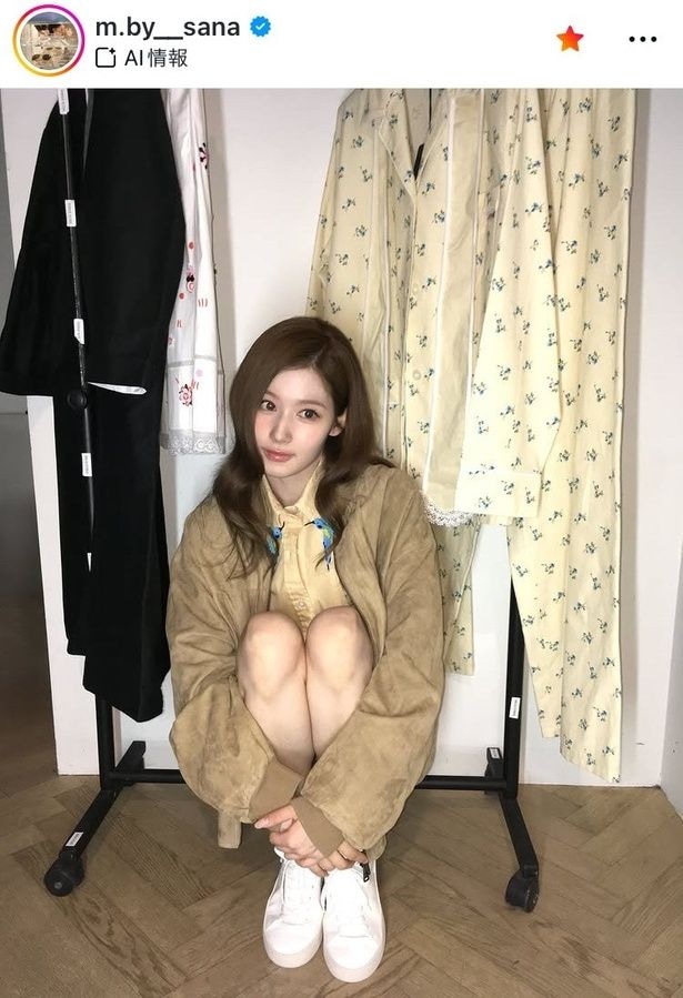 【写真】TWICE・サナ、ハンガーラックの前で膝を抱えたショット