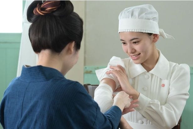 ヒデ(池田朱那)に包帯の巻き方を教えてあげるツヤ(東野絢香)