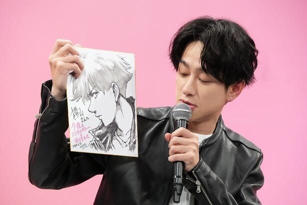 原作者からもらったイラストを手に持つ横山裕