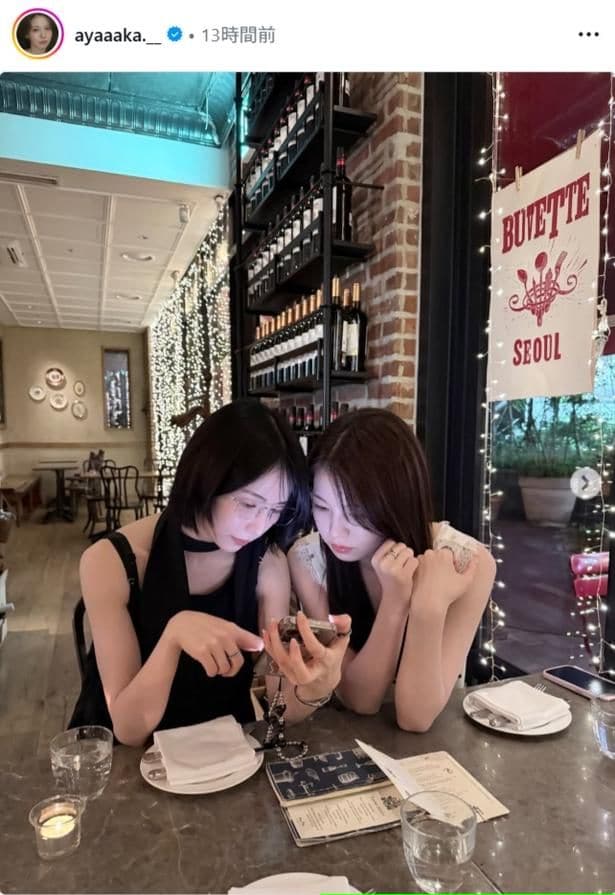 【写真】NiziU・AYAKA、MAYAとレストランで肩を寄せながらスマートフォンを見つめるショット