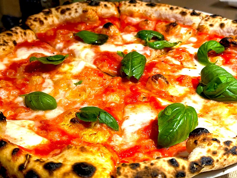 ピッツァ・マルゲリータ。もちもち濃厚なモッツァレラ・チーズと燻製パンチェッタ、グラナ・パダーノチーズが鮮やかなグラデーションの食べ応え。