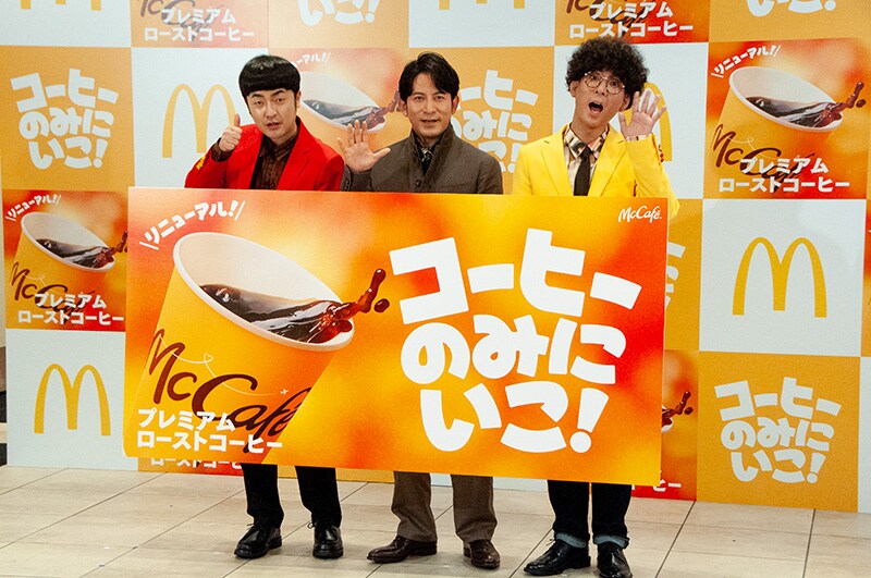 新しくなった「プレミアムローストコーヒー」(ホット)のボードを持つたくろう、岡田准一