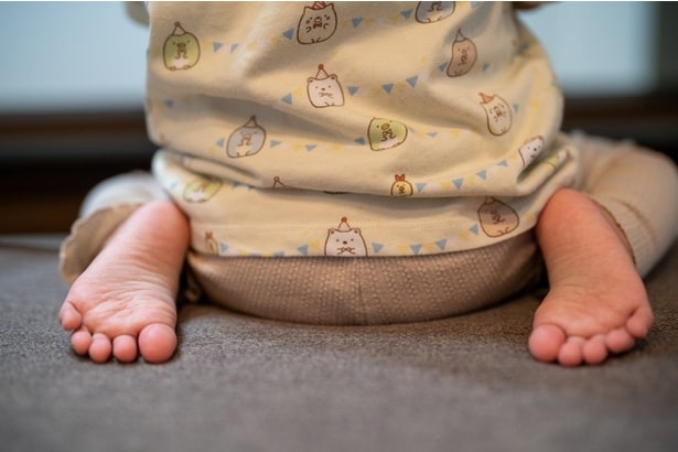 正座する子どもの後ろ姿（⇒次へ）