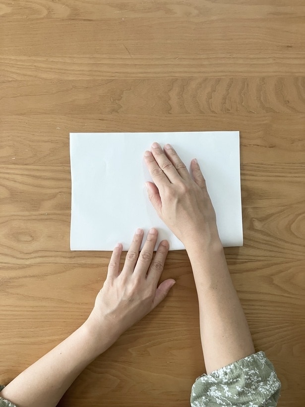 縦長に置いた紙を半分に折る（▶︎次へ）