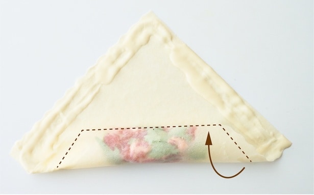 「基本の巻き方」①　春巻きの皮をひし形に置き、手前に具材を横長に重ねる。手前2辺の上半分と奥側2辺にのりをぬり、手前から1回しっかりと、さらにもう1 回少しふんわりと巻く。