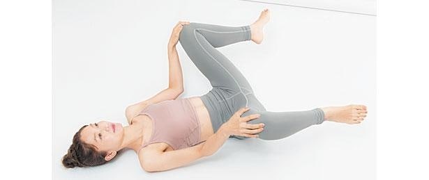 仰向けになり、ひざを閉じて上げ