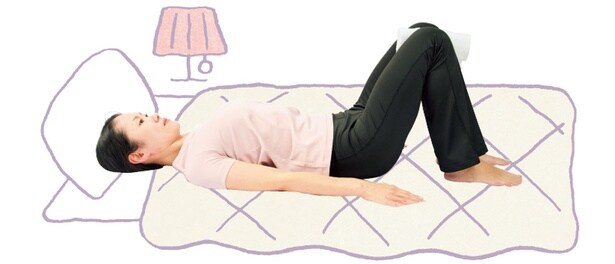 ソファーで寝っ転がりながら「ドローイン（おなかぺたんこ運動）」あおむけでひざを立て、間には丸めたタオルを挟みます。手は体の横に置き、手のひらを下に（▶︎次へ）