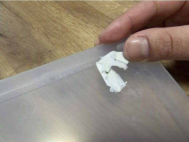 シールの表面にドライヤーの温風を30秒当てたあと、ゆっくり剥がしていく（▶次へ）