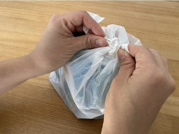 2、持ち手が固くなったら、細くした部分を両方向から結び目に押し込む。（▶次へ）