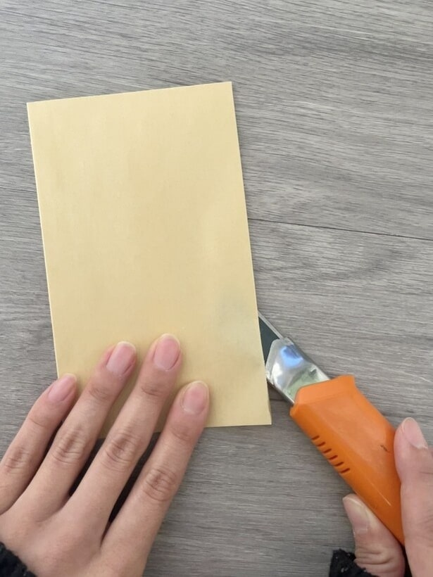 茶封筒の両サイドをカッターで切り開く(▶次へ)