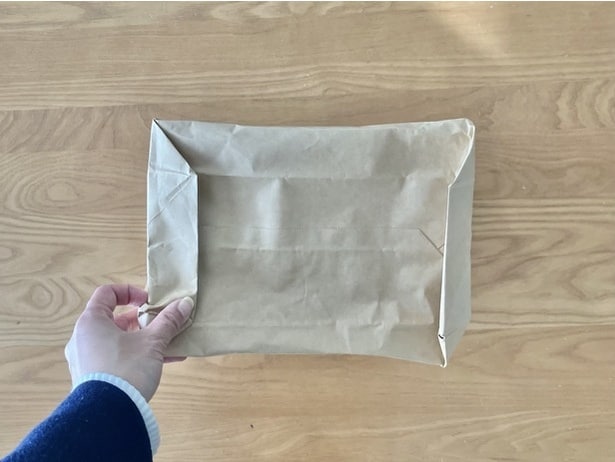 底の余った部分を紙袋の下側に折り込んだら…（▶次へ）