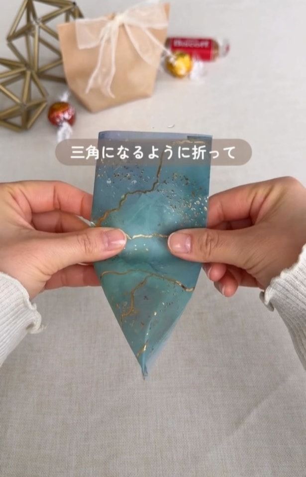 三角になるように折る▶仕上げにシールを貼って…（⇒次へ）