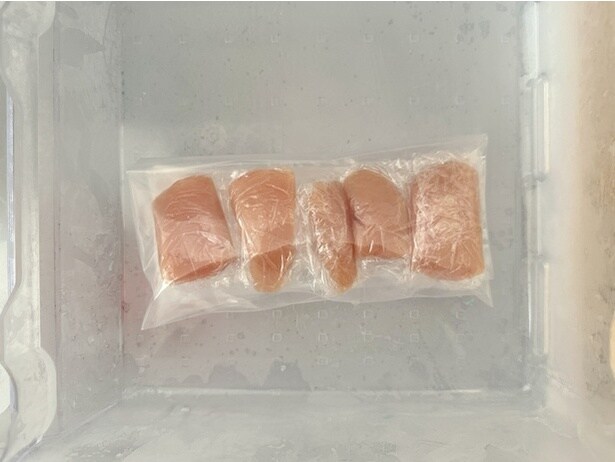 たらこをラップで包み、フリーザーバッグに入れて冷凍庫で凍らせます（▶次へ）