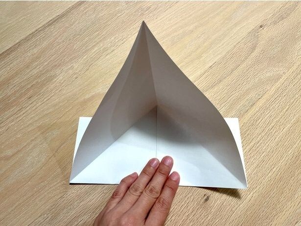 開いたら、真ん中を押さえて底にしっかりと折り目をつける(▶次へ)