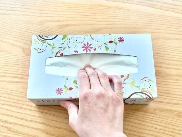 箱ティッシュの中央部分を、くぼみができるくらいまで押します（▶次へ）