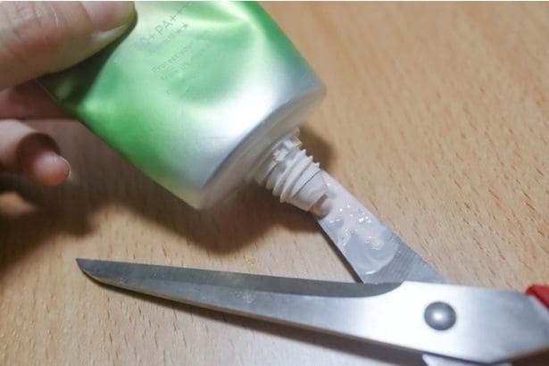 はさみの刃に日焼け止めクリームを乗せる（▶次へ）