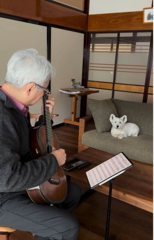 飼い主さんのギター演奏を聴き入る「シロップくん」（⇒次へ）