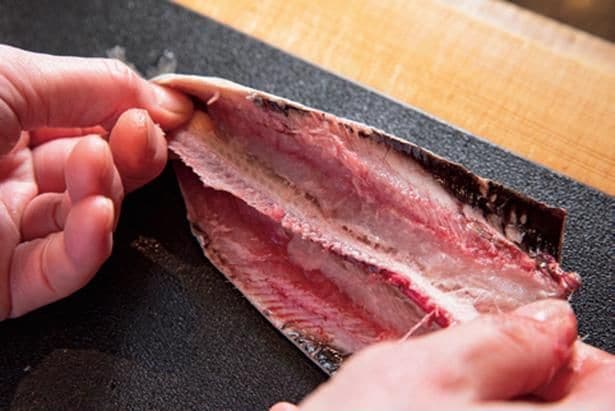 いわしのさばき方3　中骨の下にもまん中から親指を入れ、中骨に沿って両脇に動かして骨をはがし、切り落とす